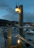 Handcrafted marine lantern glowing softly on a fishing boat at dusk.