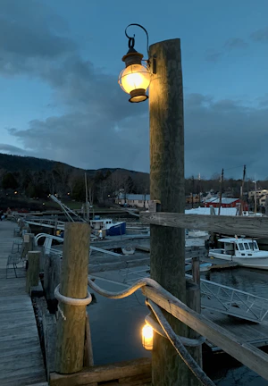 Handcrafted marine lantern glowing softly on a fishing boat at dusk.
