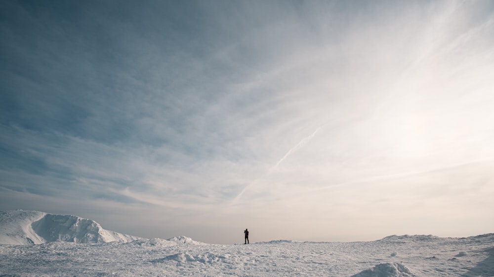 a person standing on top of a snow covered slope