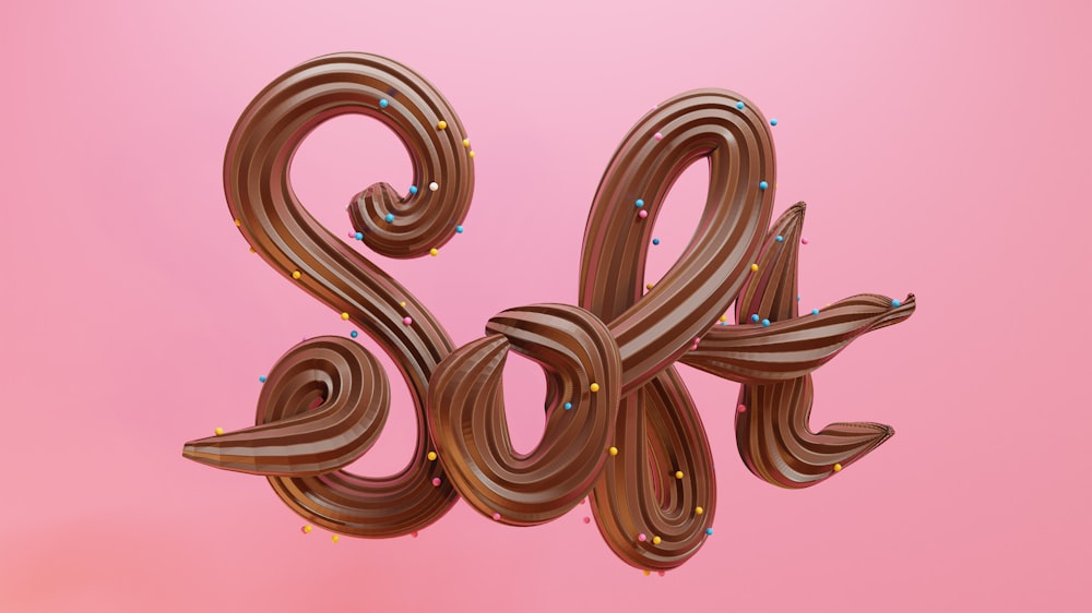 un numero di cioccolato a forma di serpente su uno sfondo rosa