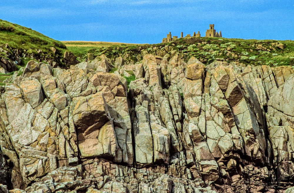 a rocky cliff with a castle on top of it