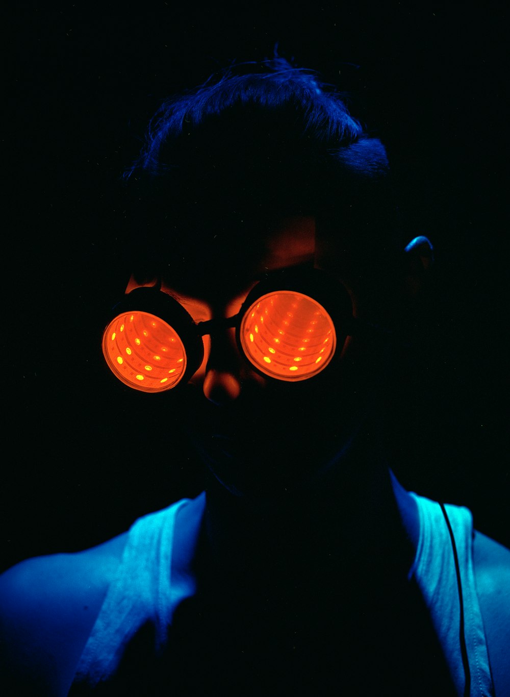 a man wearing a pair of red goggles in the dark