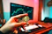 a person holding a coin in front of a computer