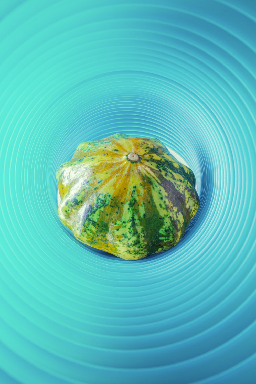 a watermelon in a blue bowl with ripples