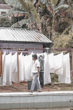 A friendly staff member picking up laundry from a tropical Ubud home.