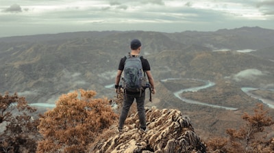 a man standing on top of a mountain with a backpack