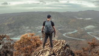 a man standing on top of a mountain with a backpack