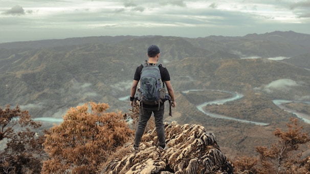 a man standing on top of a mountain with a backpack