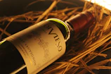 Elegant bottle of Vignaviva red wine with a rustic vineyard background.