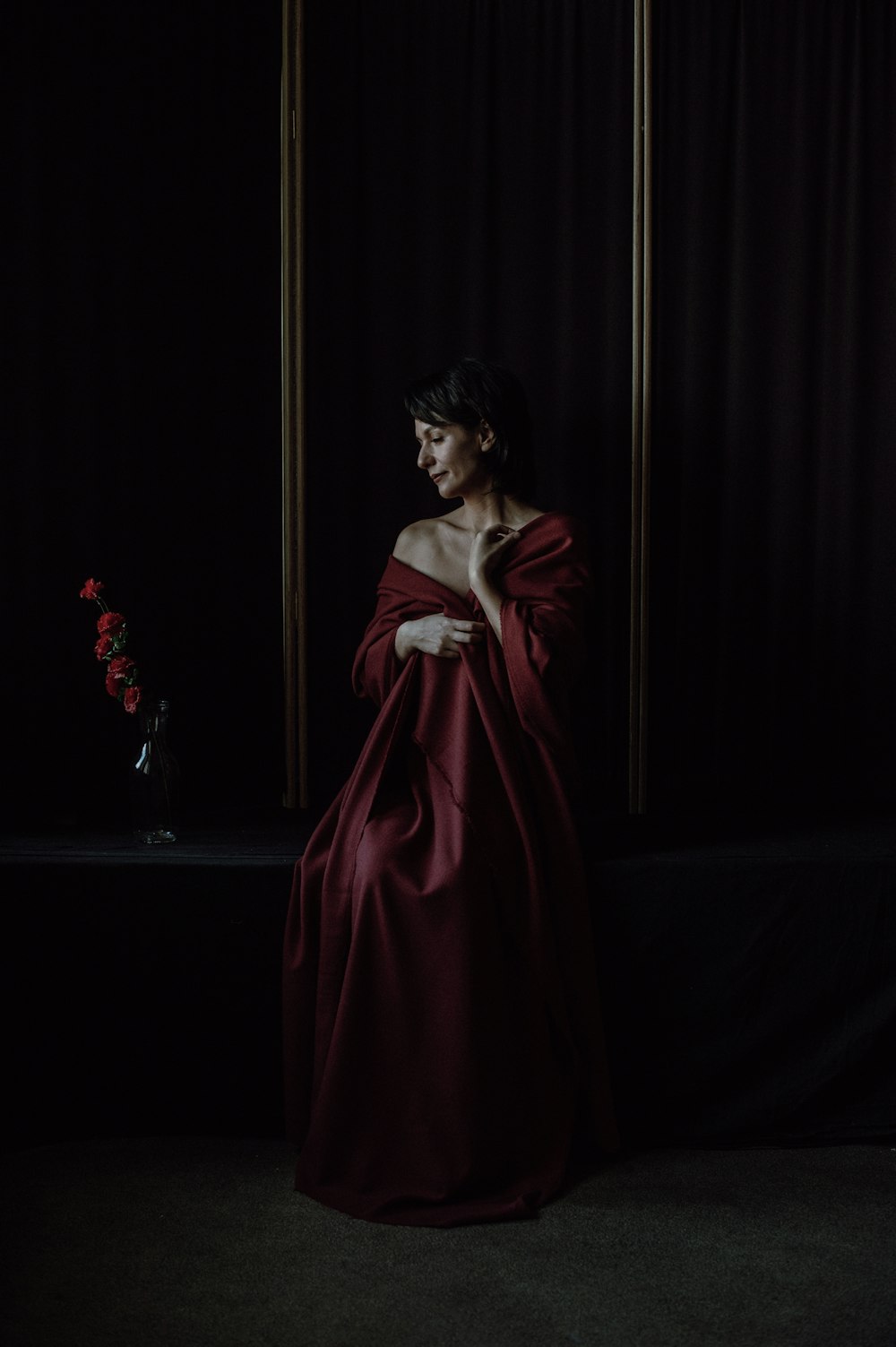 a woman in a red dress standing in a dark room