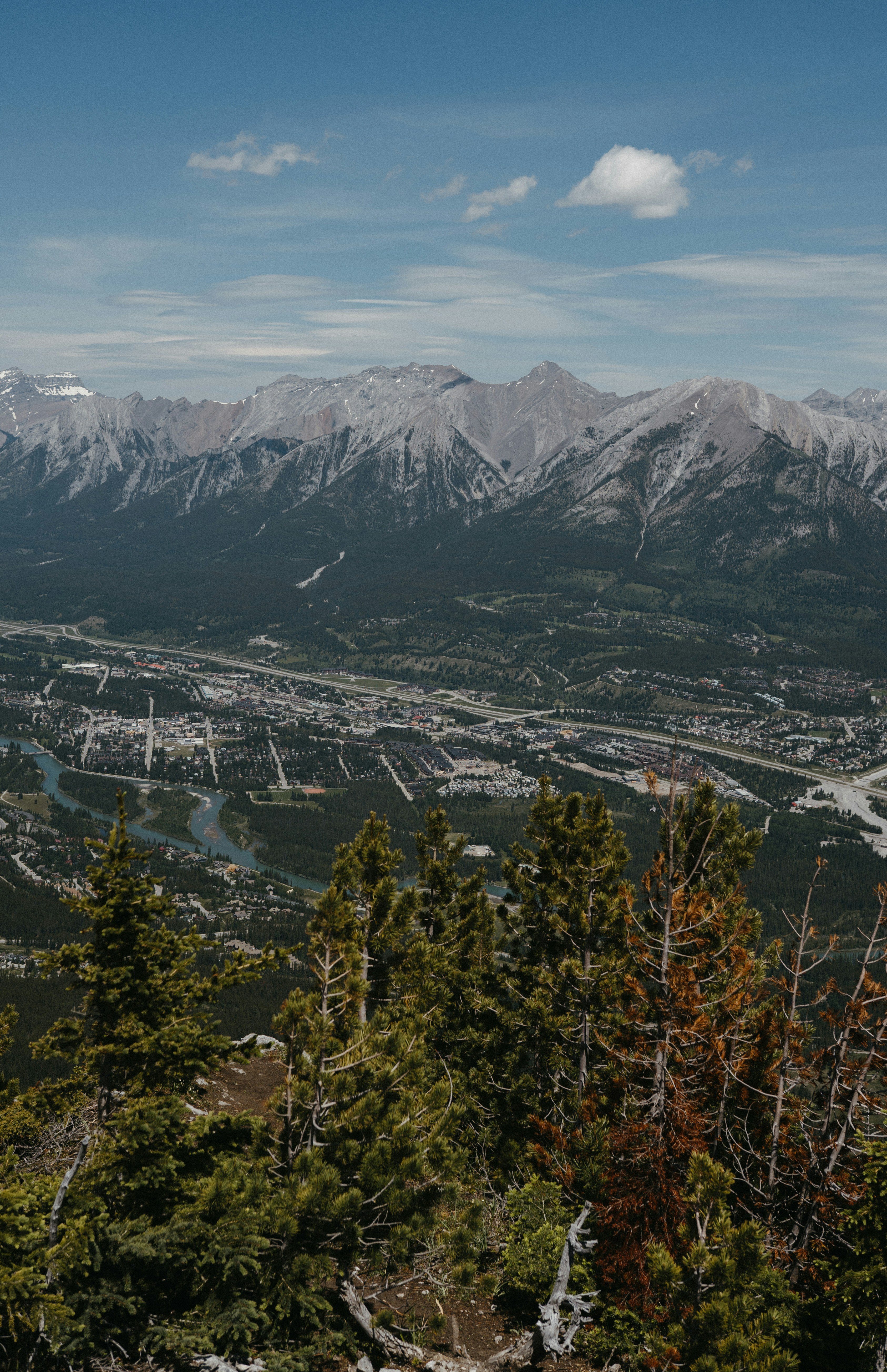 a view of a city and mountains from the top of a hill