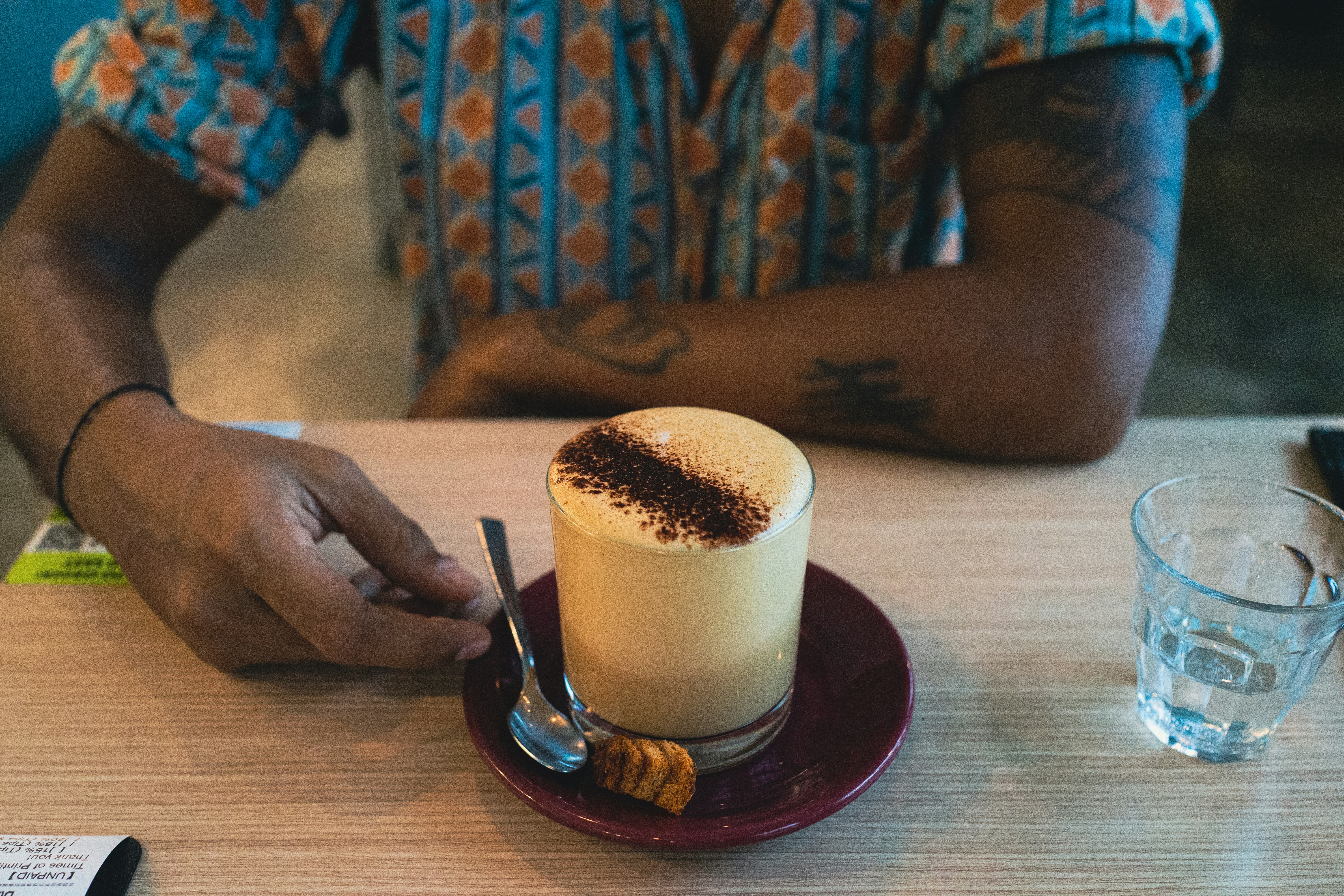 seseorang yang duduk di meja dengan secangkir kopi