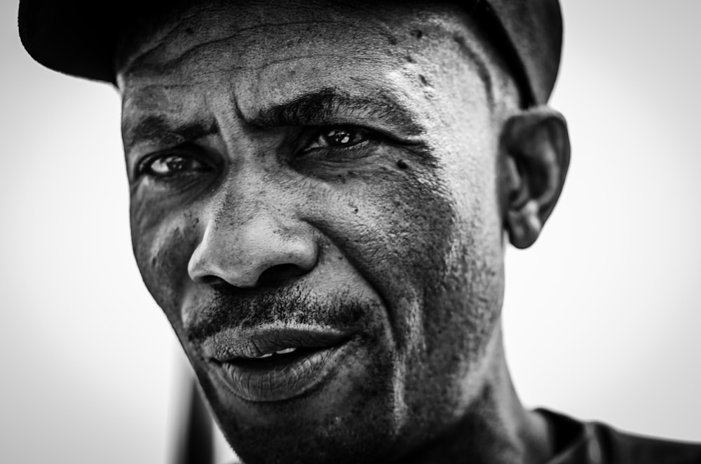 a black and white photo of a man wearing a hat