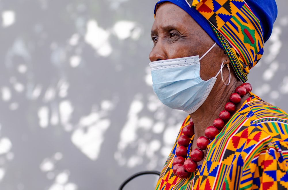 a woman wearing a face mask and beads