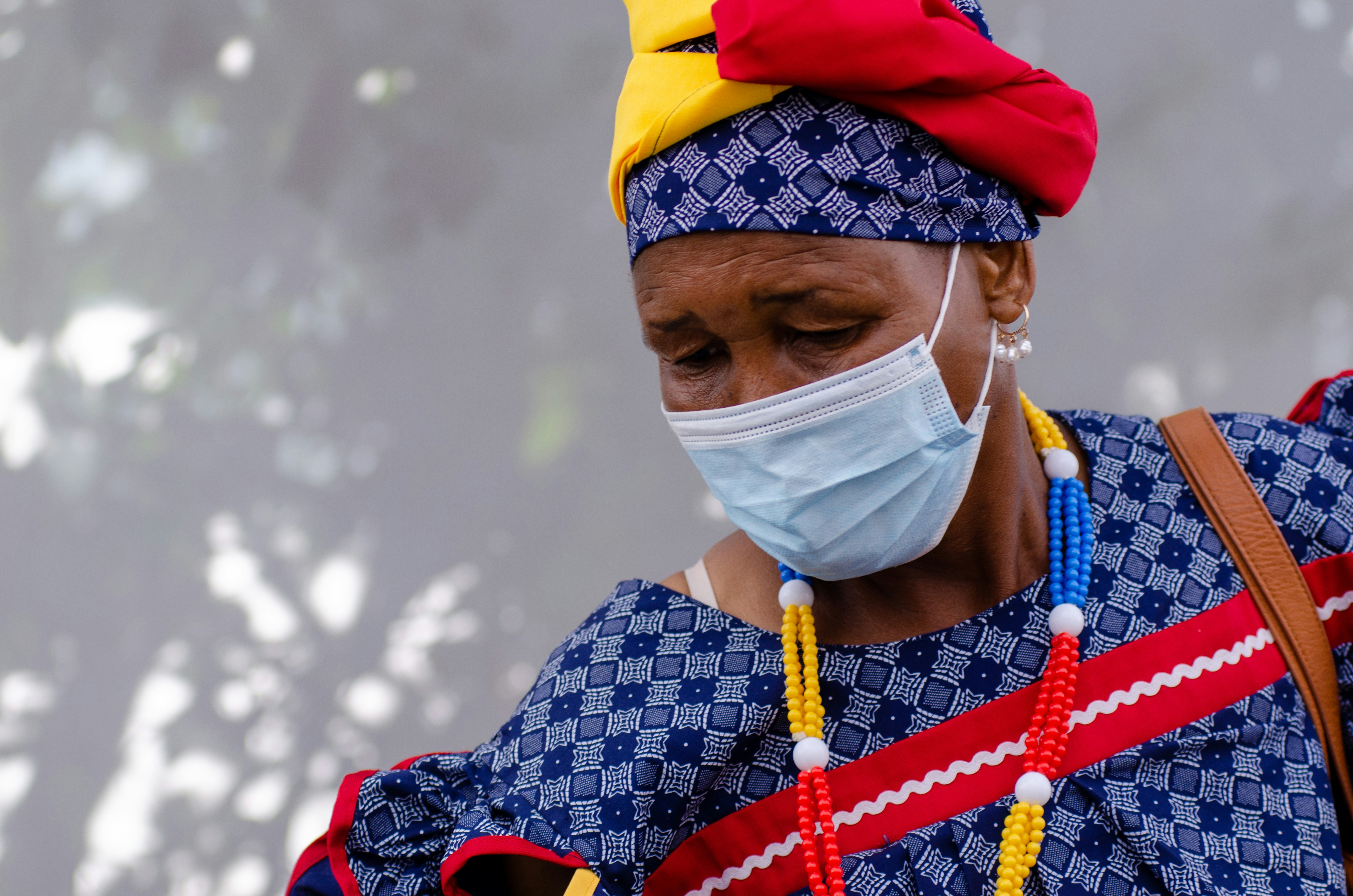 a woman wearing a face mask and a colorful necklace