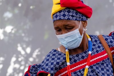 a woman wearing a face mask and a colorful necklace