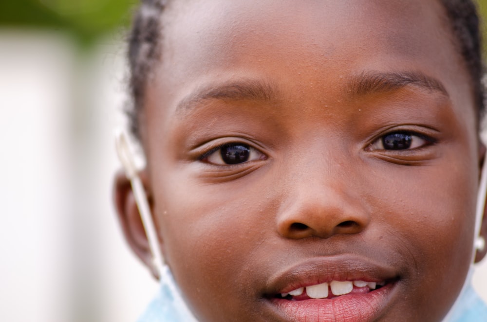 a close up of a child wearing a blue shirt