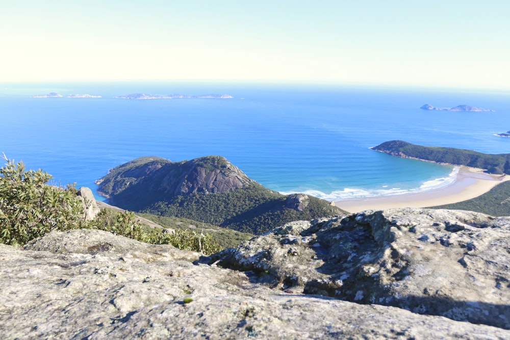 a view of a beach from a rocky outcropping