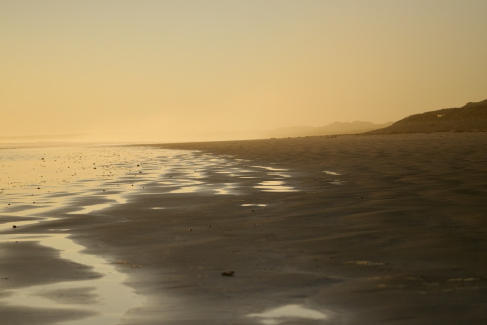 a sandy beach with waves coming in to shore