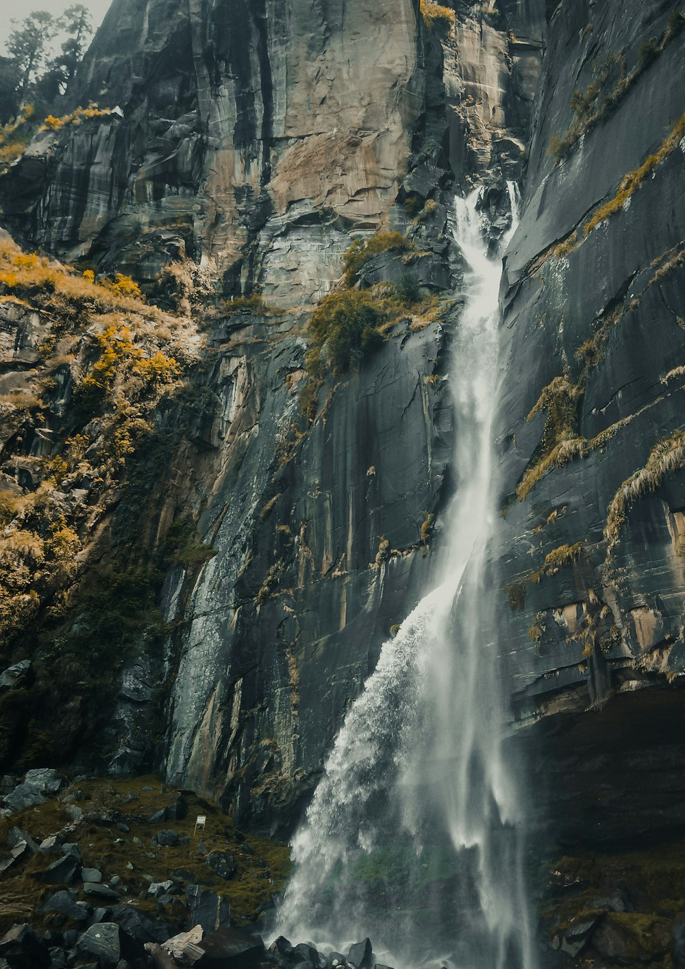 a tall waterfall with water cascading down it's side