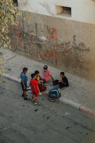 a group of young boys standing around a boy on a skateboard