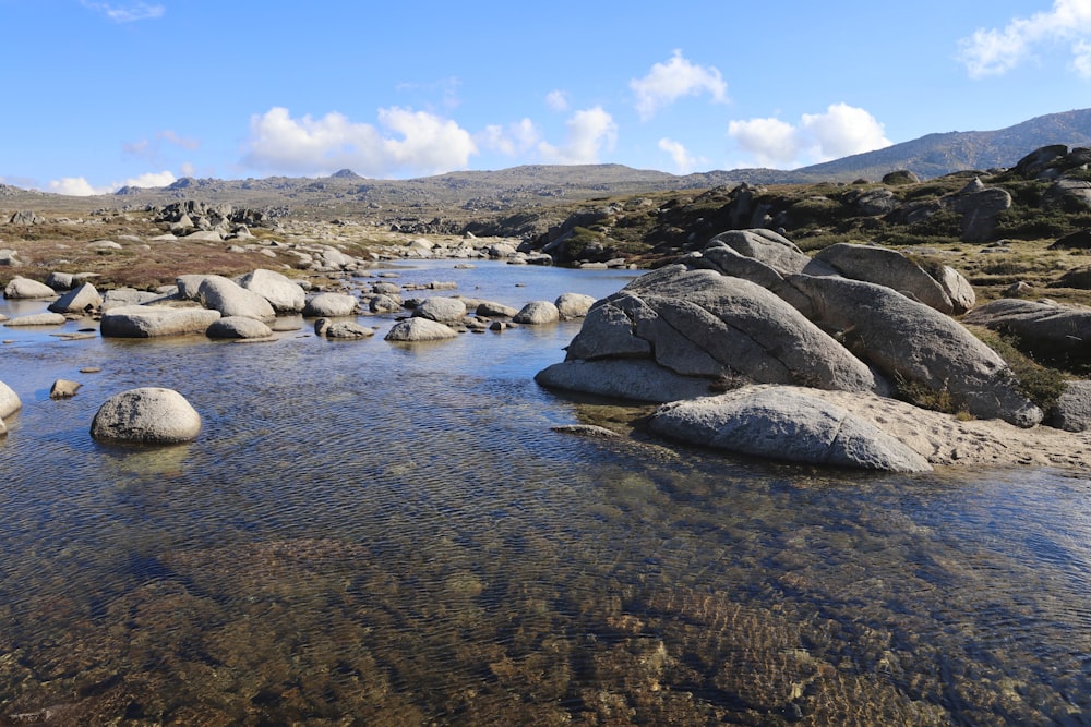 a stream running through a rocky mountain valley