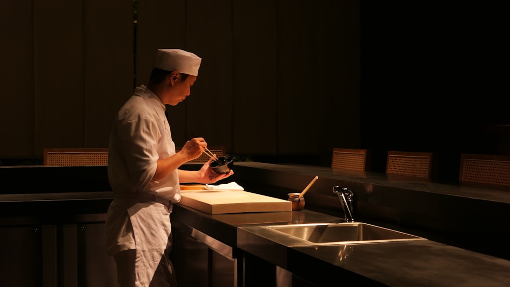 a man standing in a kitchen next to a sink