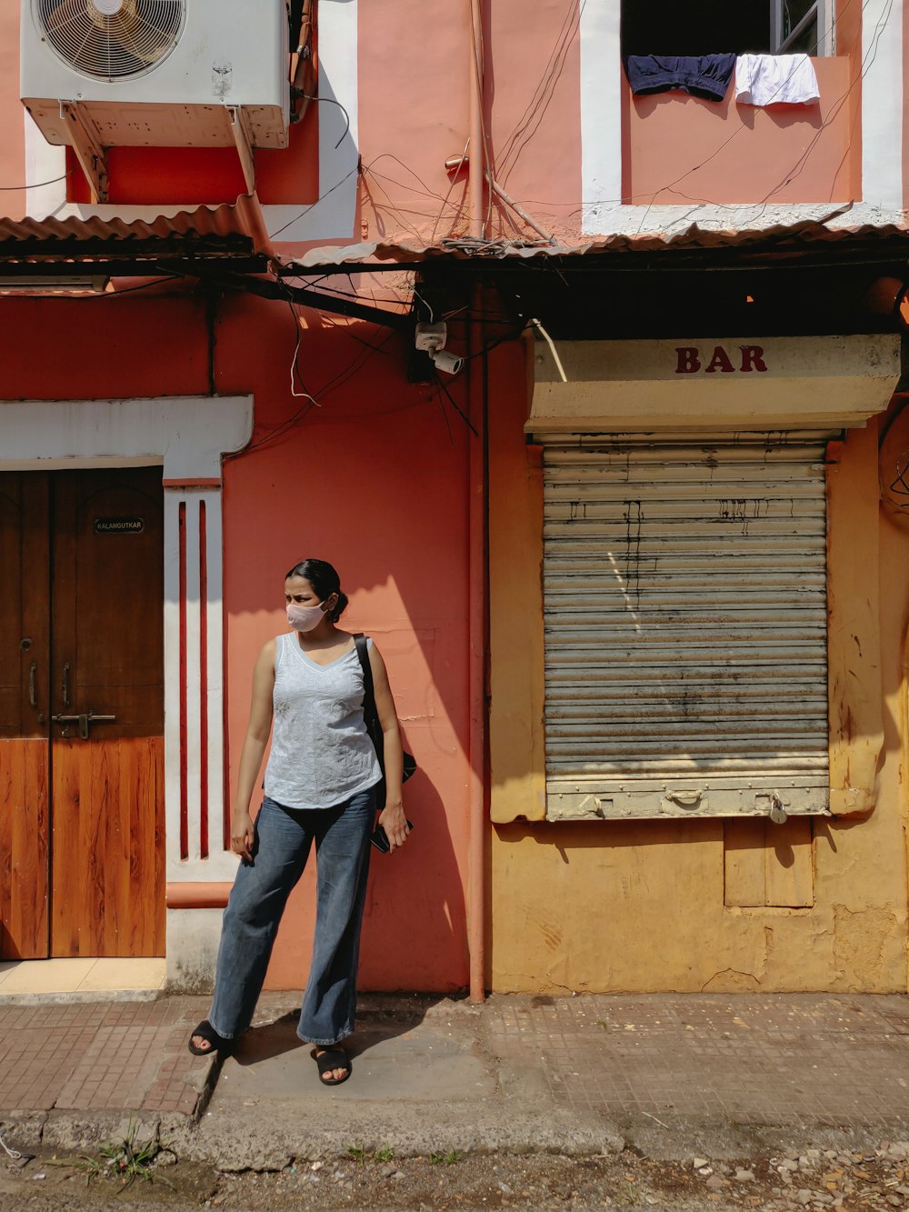 a woman standing in front of a pink building