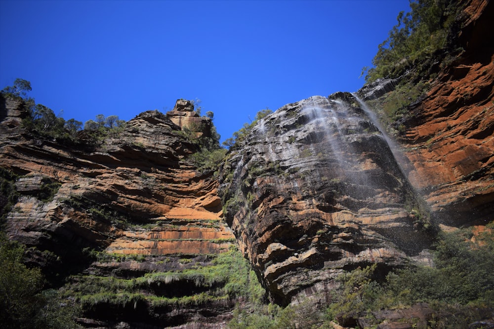 a waterfall cascading down a cliff into a blue sky