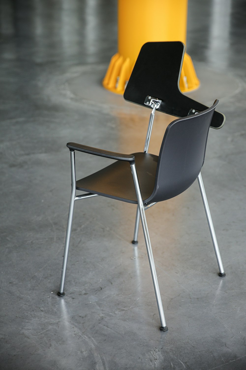 a black and brown chair sitting on top of a cement floor