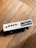 A small electronic device with multiple ports, including USB, ethernet, and audio jacks, resting on a wooden surface. The device is white with a rectangular shape and appears to be positioned at an angle.
