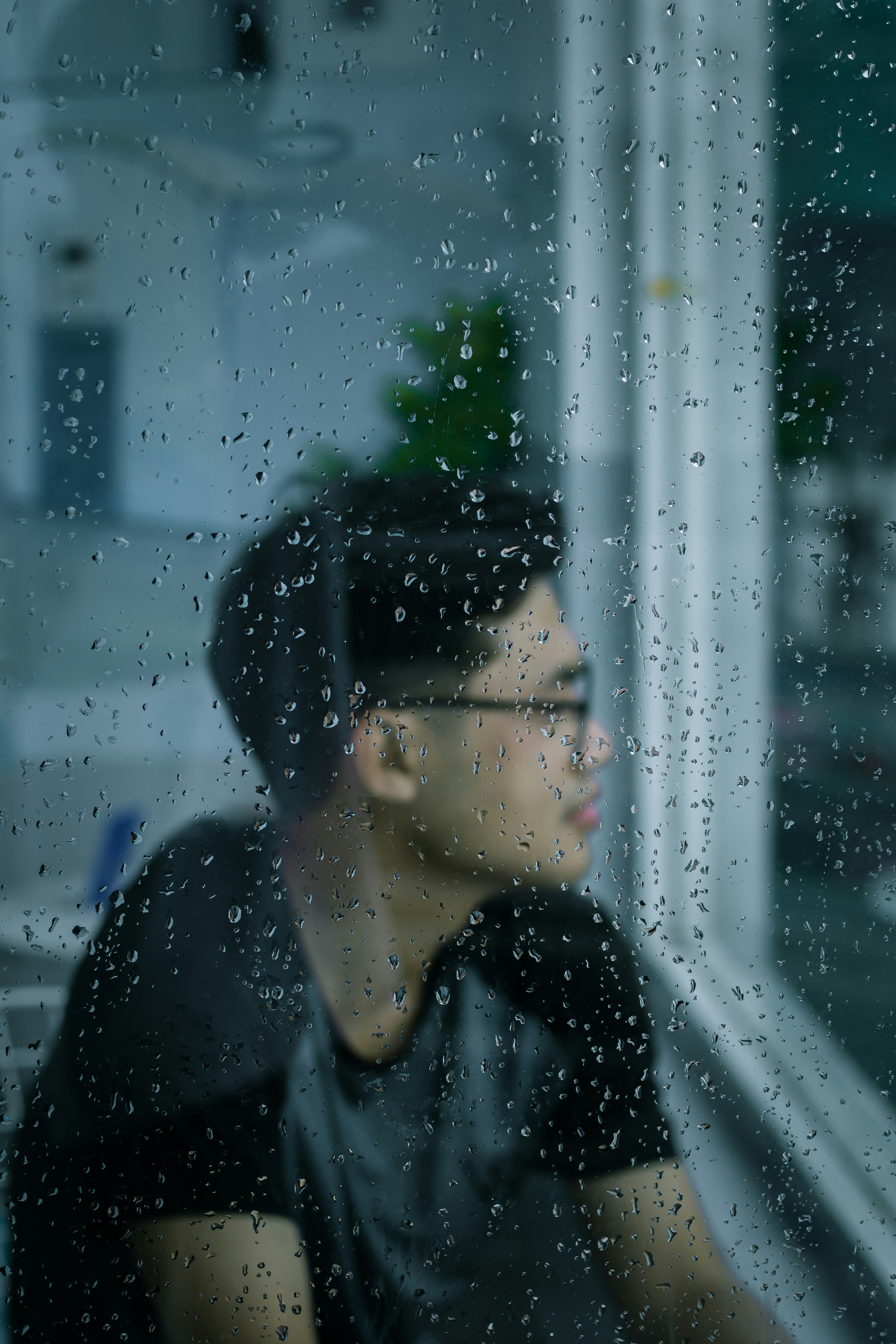 A man looking out of a window in the rain photo – Free Woman Image on ...