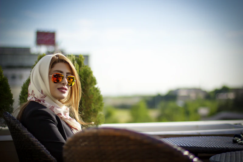 Güneş gözlüklü oturan kadın