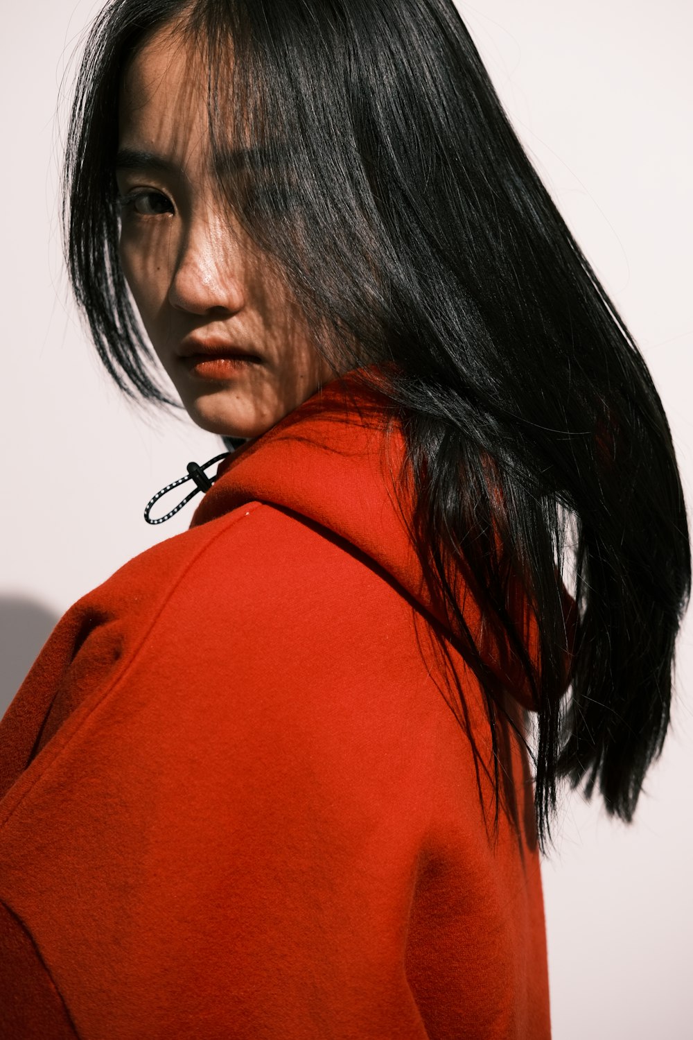 a woman in a red jacket with a black tie around her neck