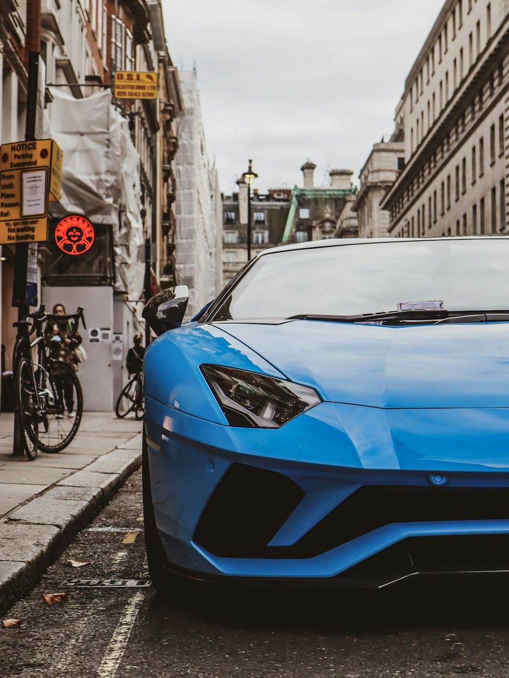 a blue sports car parked on the side of the road