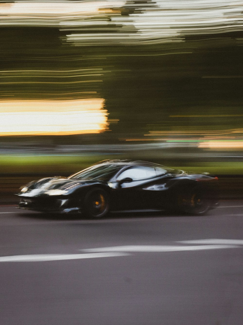 a black sports car driving down a street