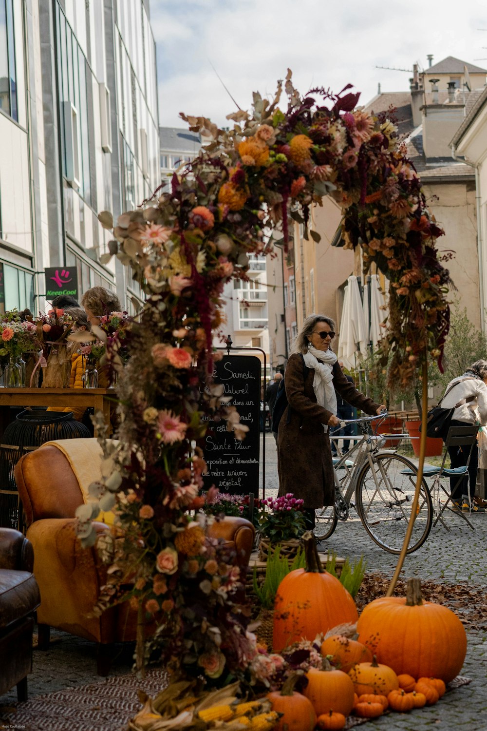 a woman standing next to a bunch of pumpkins