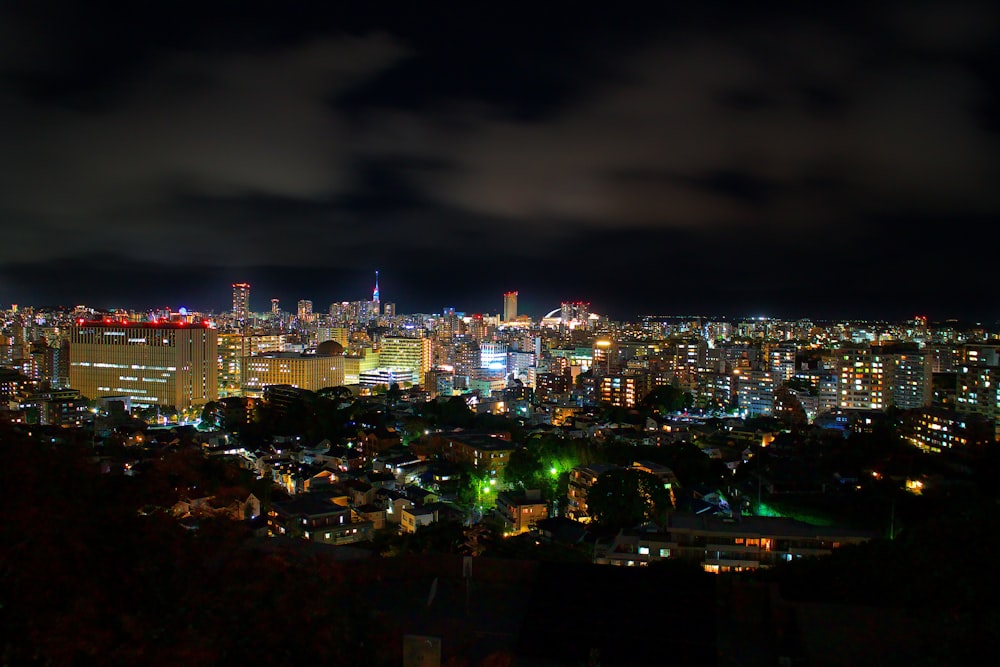 Una vista di una città di notte dalla cima di una collina