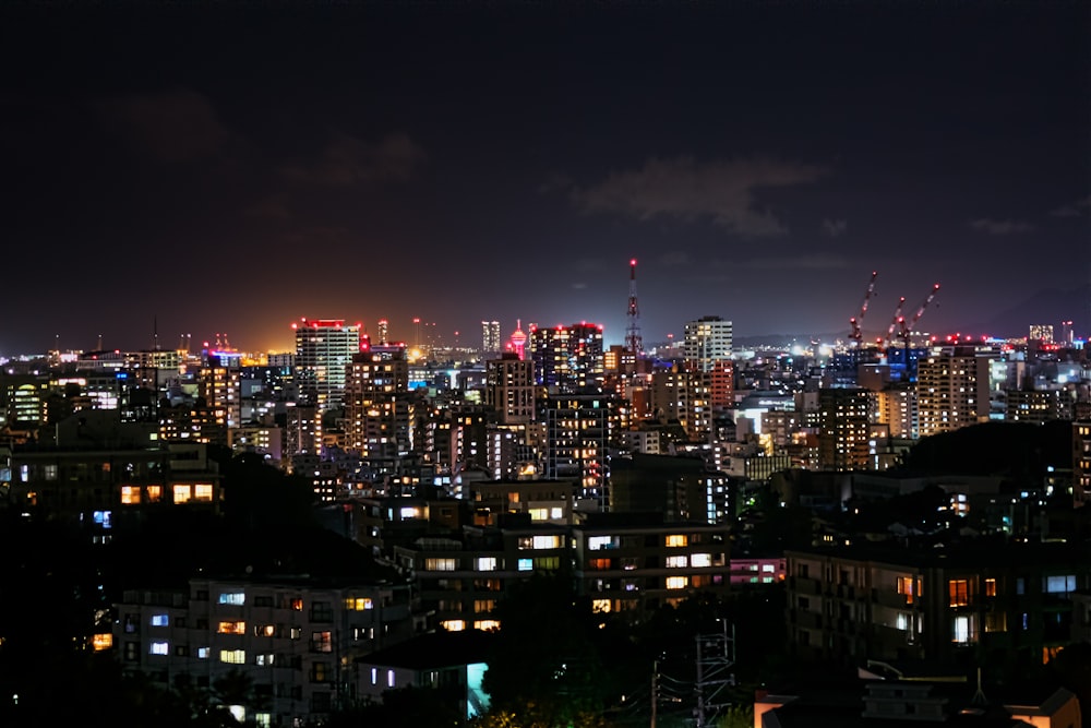 Una vista de una ciudad por la noche desde la cima de una colina