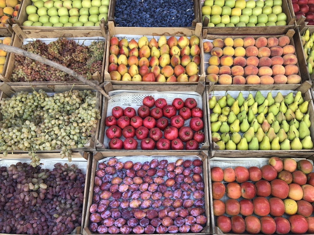 un tas de boîtes remplies de différents types de fruits