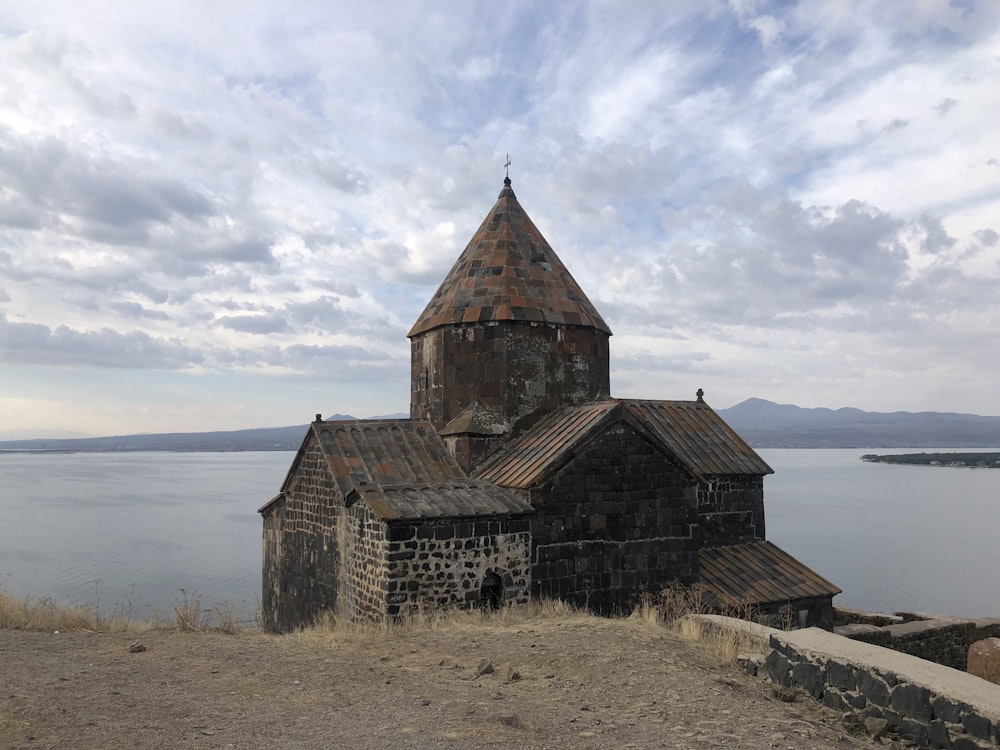 an old church on a hill overlooking a body of water