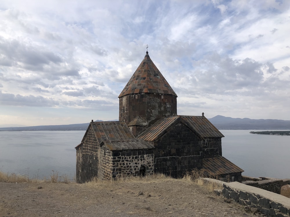 Una antigua iglesia en una colina con vistas a un cuerpo de agua