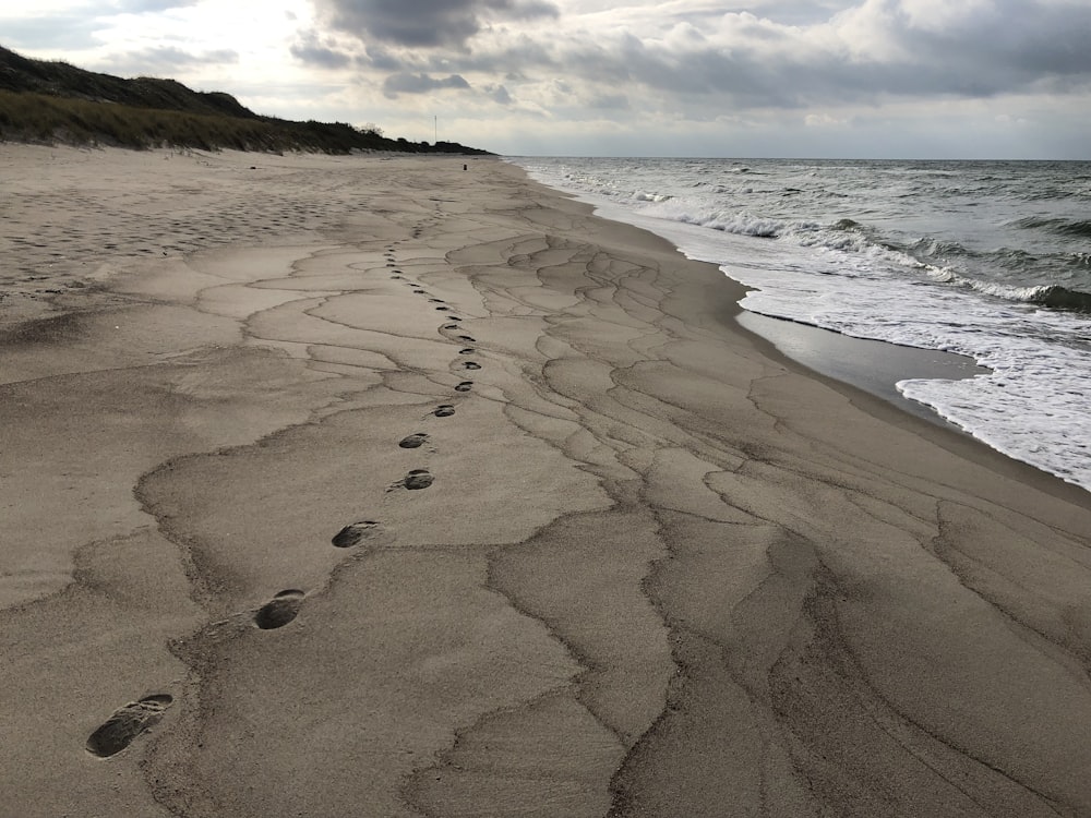 a sandy beach with footprints in the sand