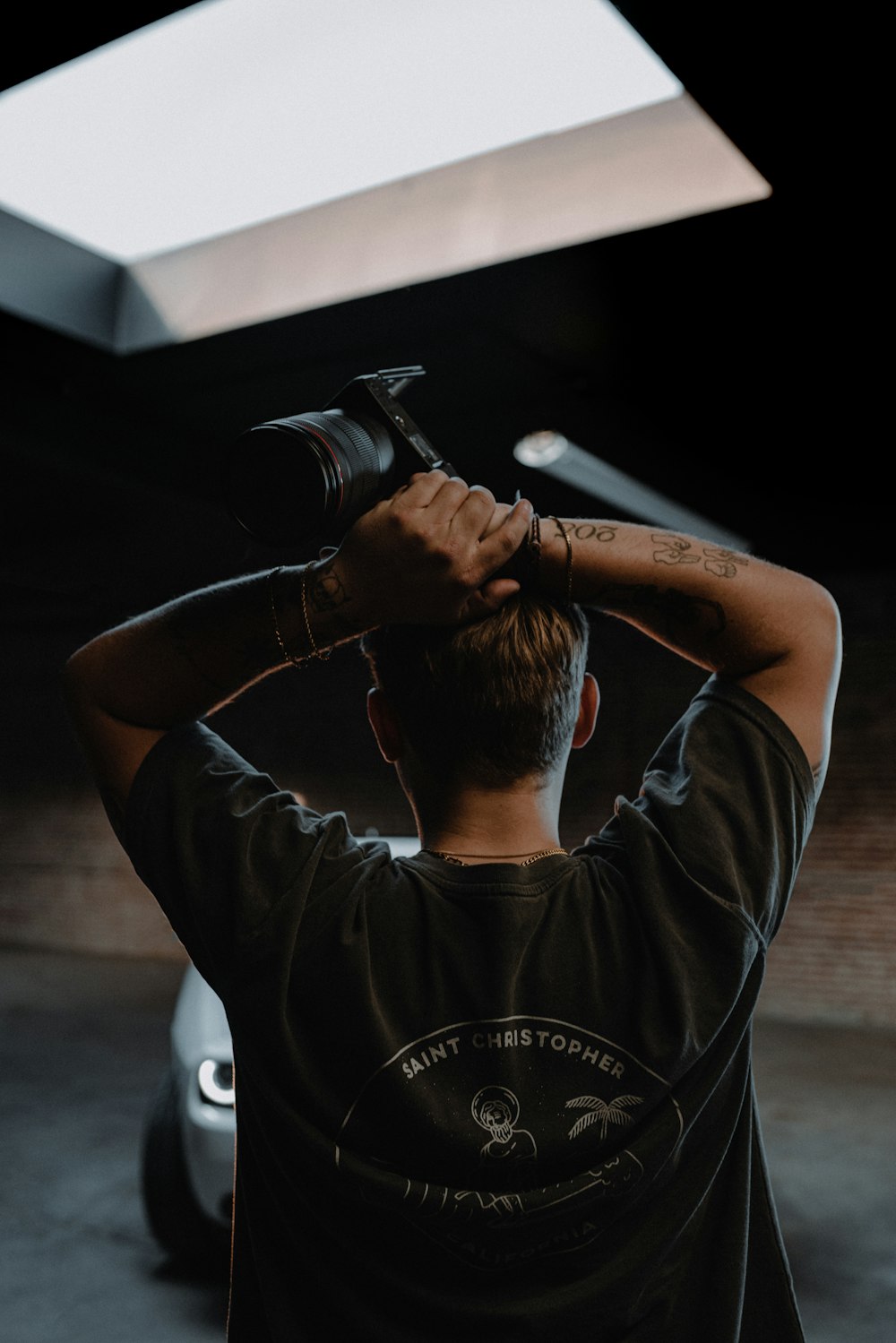 a man holding a camera up to his head