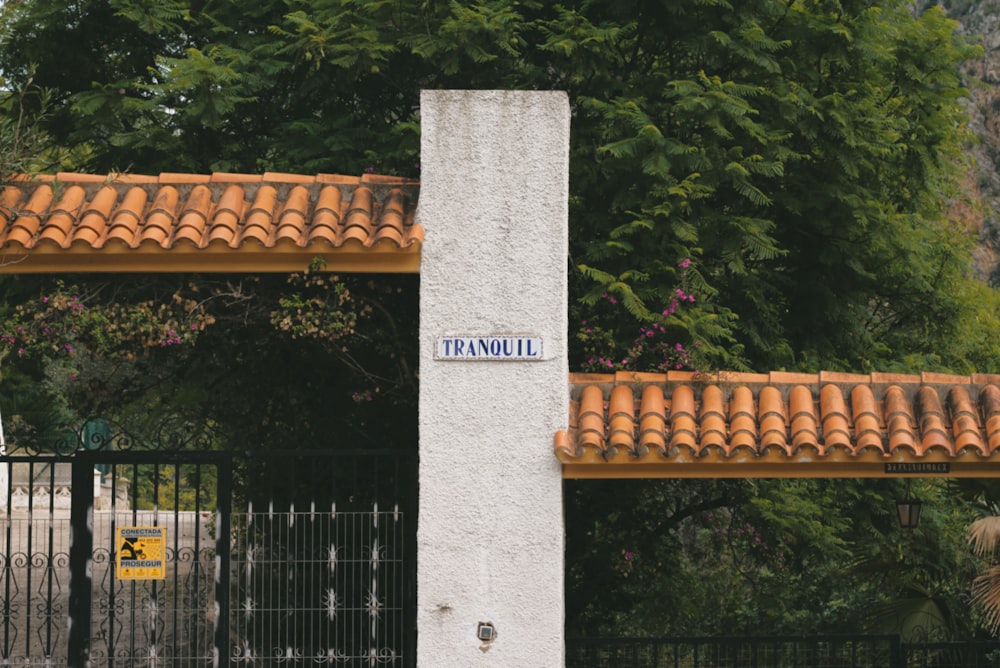 a tall white pillar sitting next to a fence