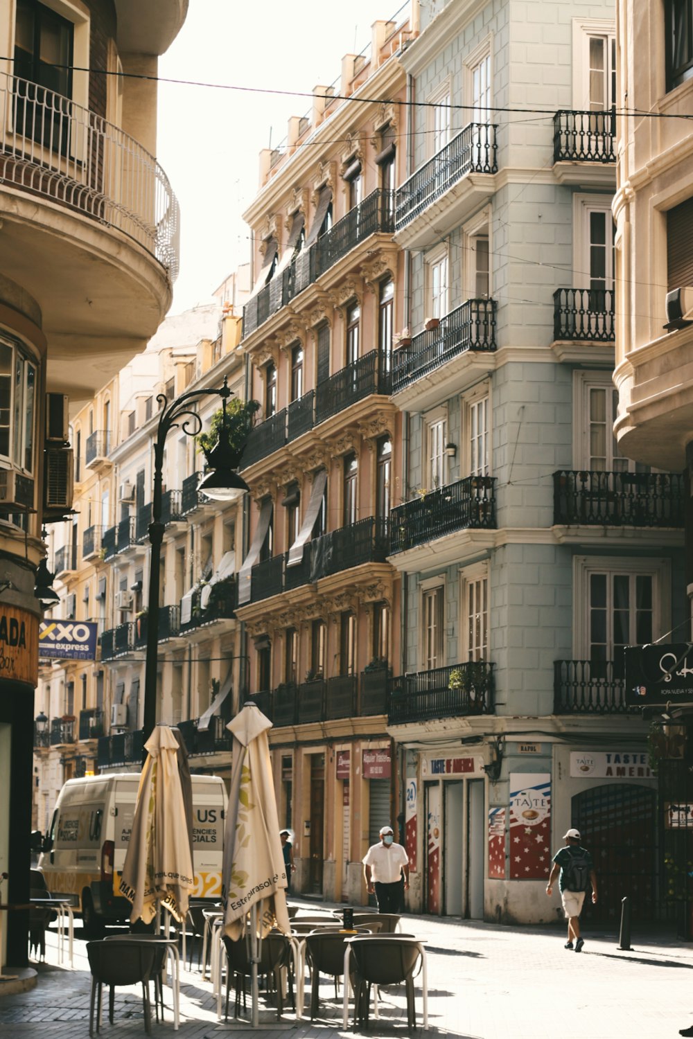 a group of people walking down a street next to tall buildings