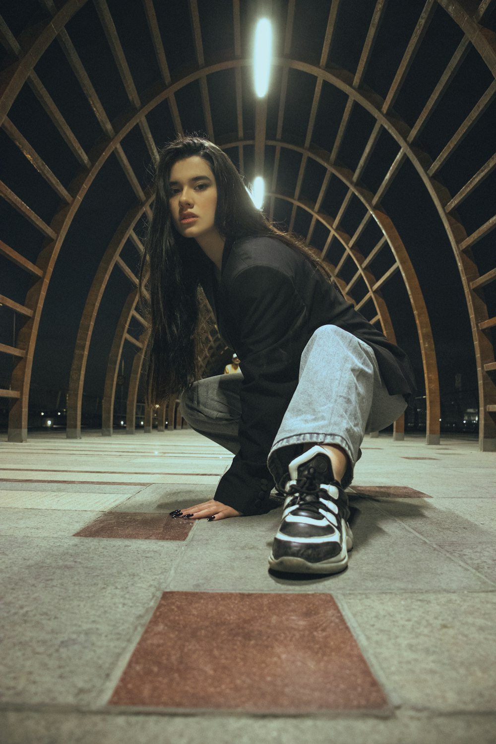 a woman sitting on the ground in a tunnel