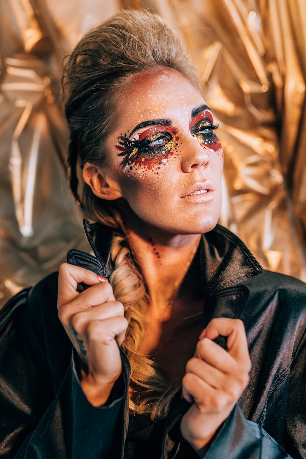 a woman in a black leather jacket with makeup on her face