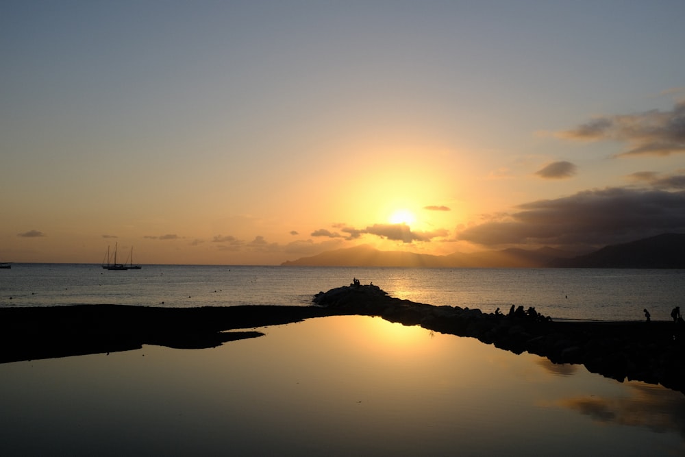 the sun is setting over a body of water