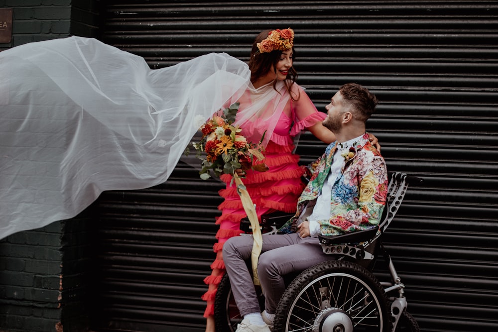 a man in a wheelchair being pushed by a woman